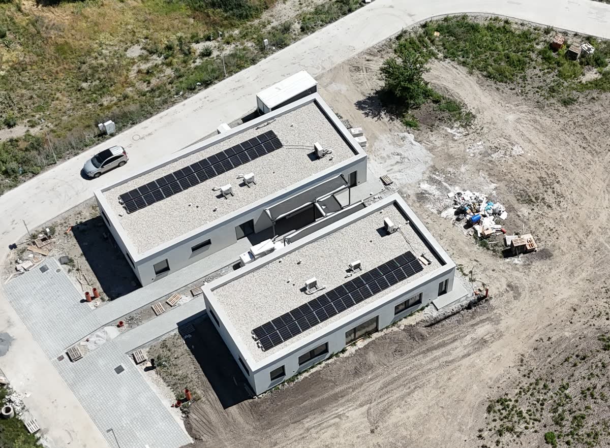 Dvojica budov s fotovoltickými panelmi na plochých strechách